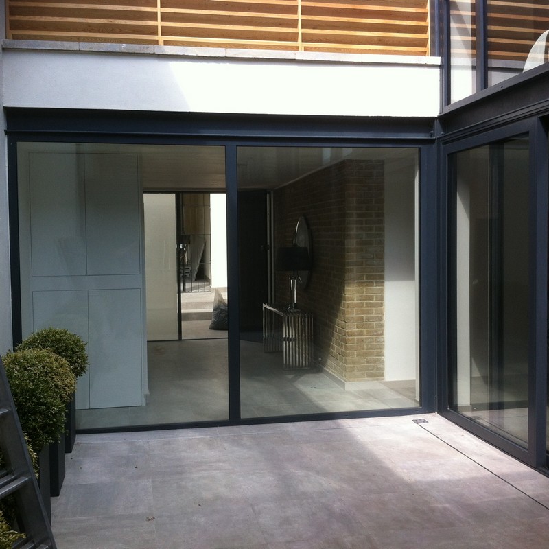 Floor-to-ceiling sliding doors opening to courtyard in Lee