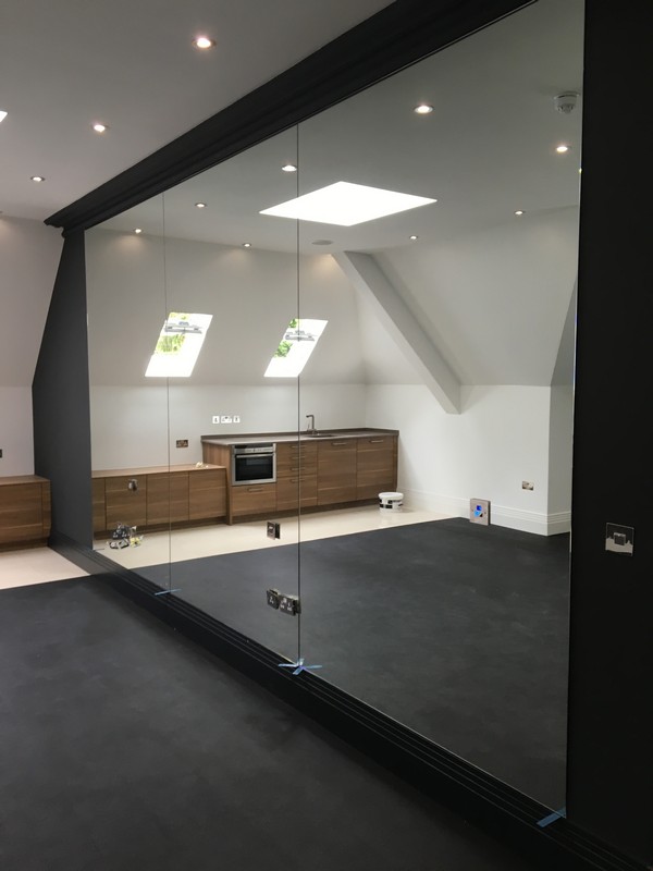 Frameless glass partition in loft conversion by Lee glaziers