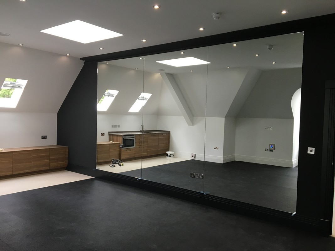 Frameless glass wall dividing loft conversion in Lee